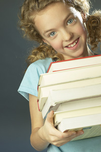photo of young girl holding books